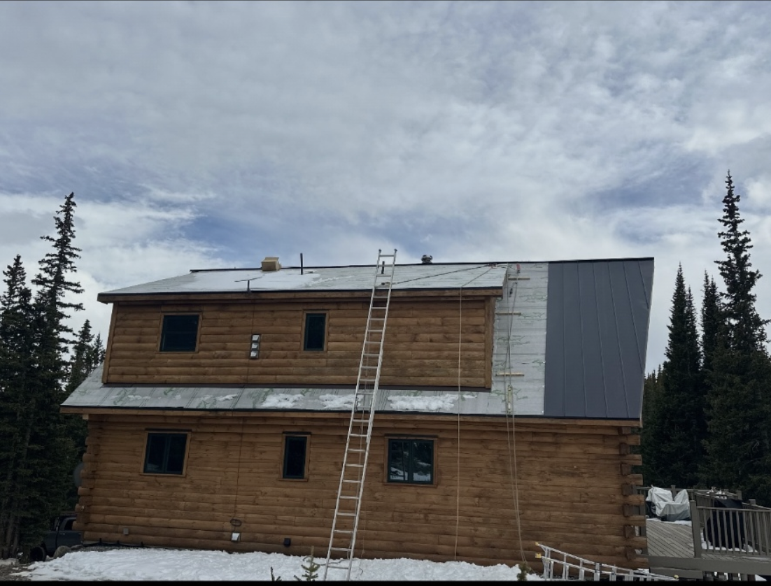 Wooden cabin with metal roofing installation
